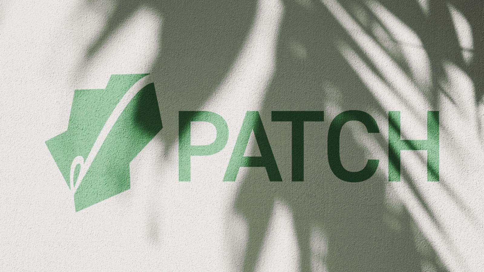 The Patch mark and wordmark painted in green on a white wall