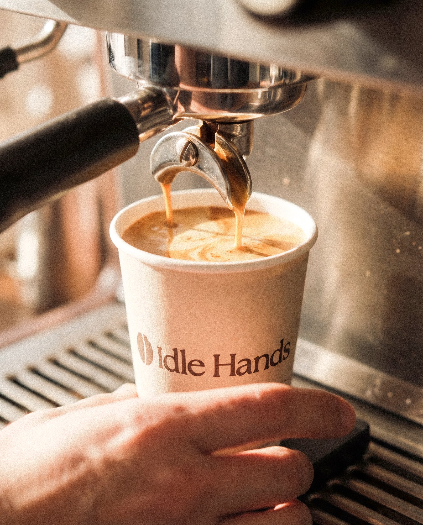 Idle Hands takeaway cup with the bean mark and the line Carefully brewed