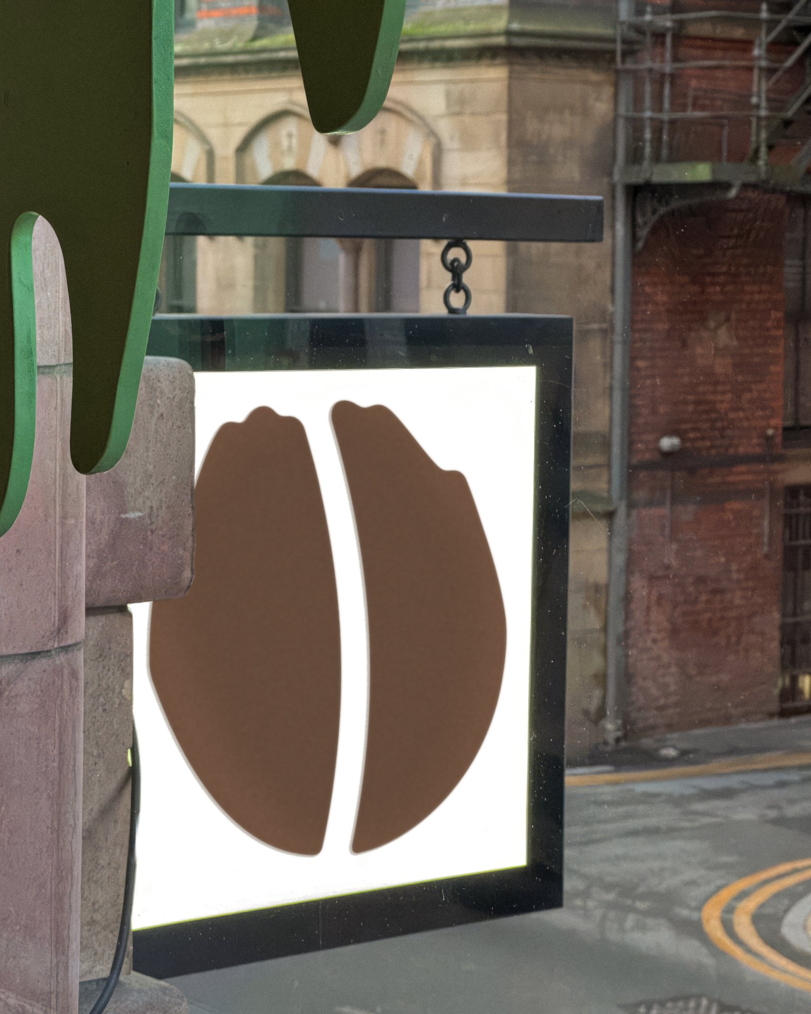 Idle Hands coffee-bean mark on a hanging lightbox sign