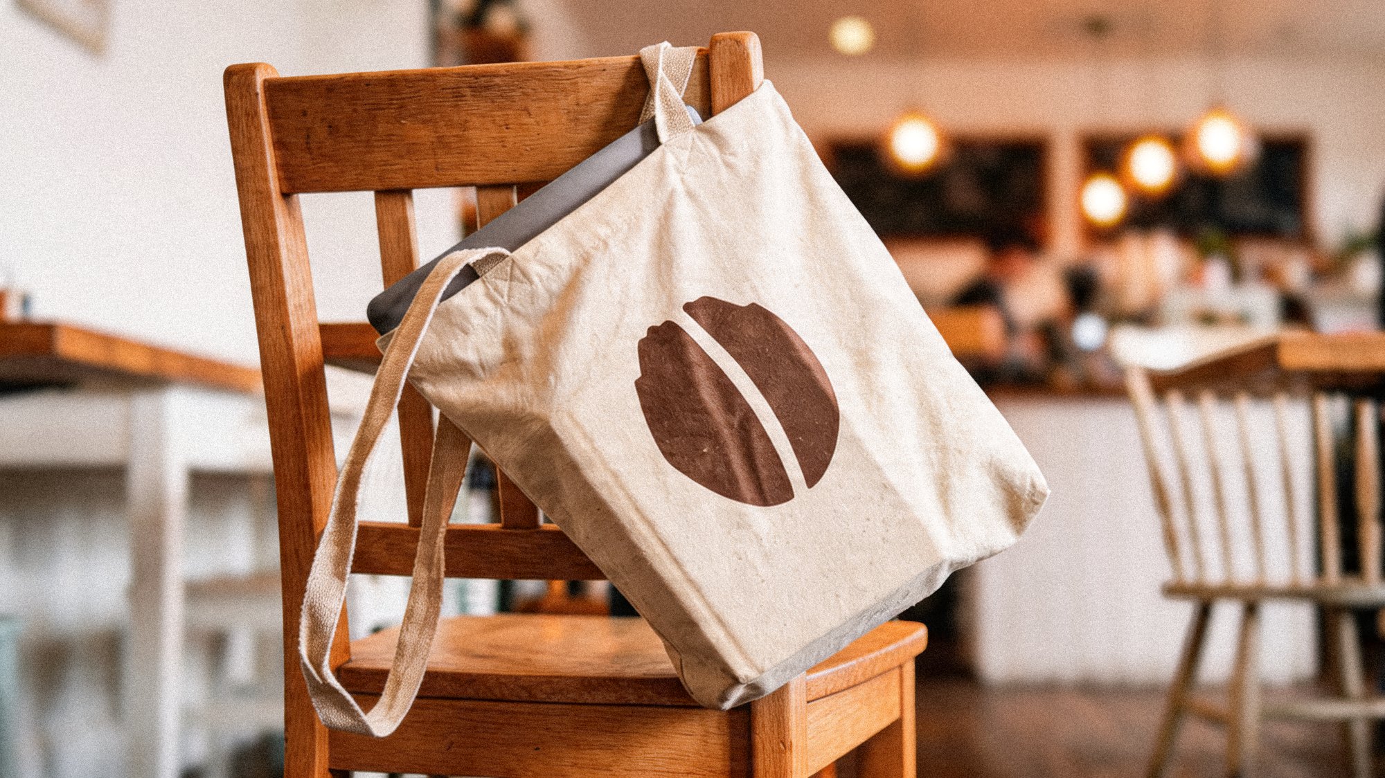 Idle Hands tote bag on a café chair