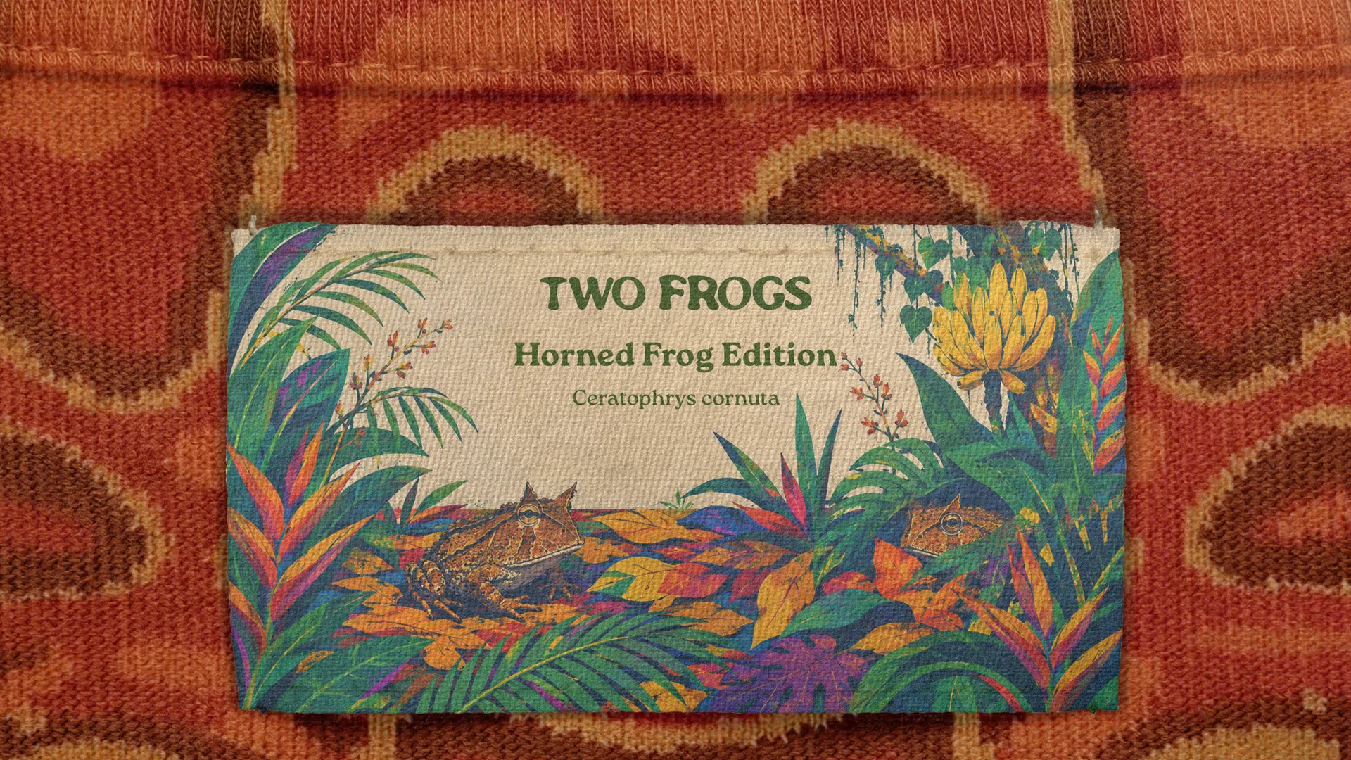 Two Frogs Horned Frog Edition label on a rust knit, two horned frogs hidden in jungle leaves